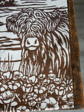 Close up of highland cow calf on brown fabric