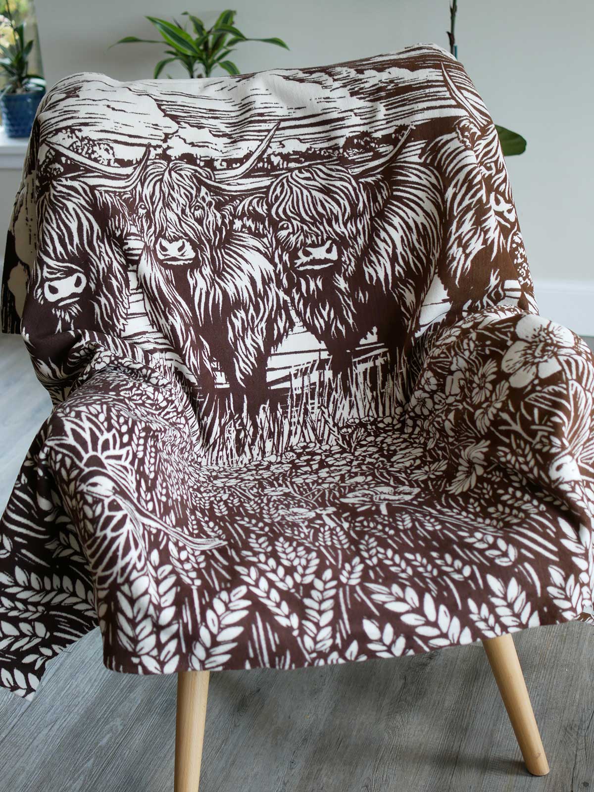 Throw with highland cow design on a chair