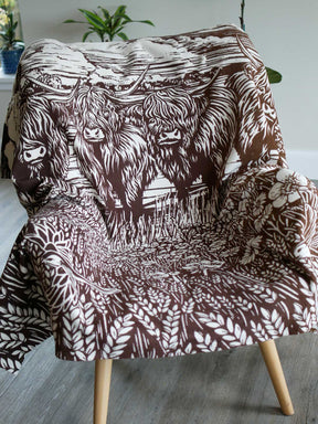Throw with highland cow design on a chair