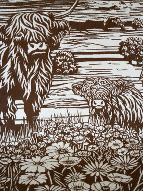 Close up of a brown throw a highland cow and calf