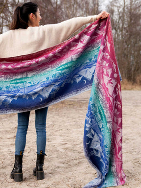 Person holding a colourful woven wrap with a natural background