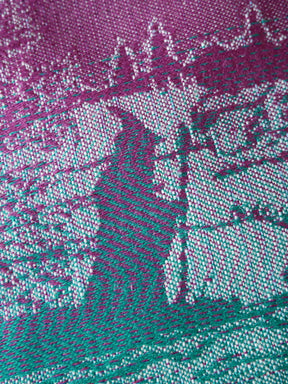 Close-up of a textured fabric with a pattern of intersecting lines in purple and green.