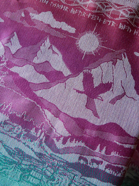 Textile with garnet and green design of mountains, sun, and landscape.