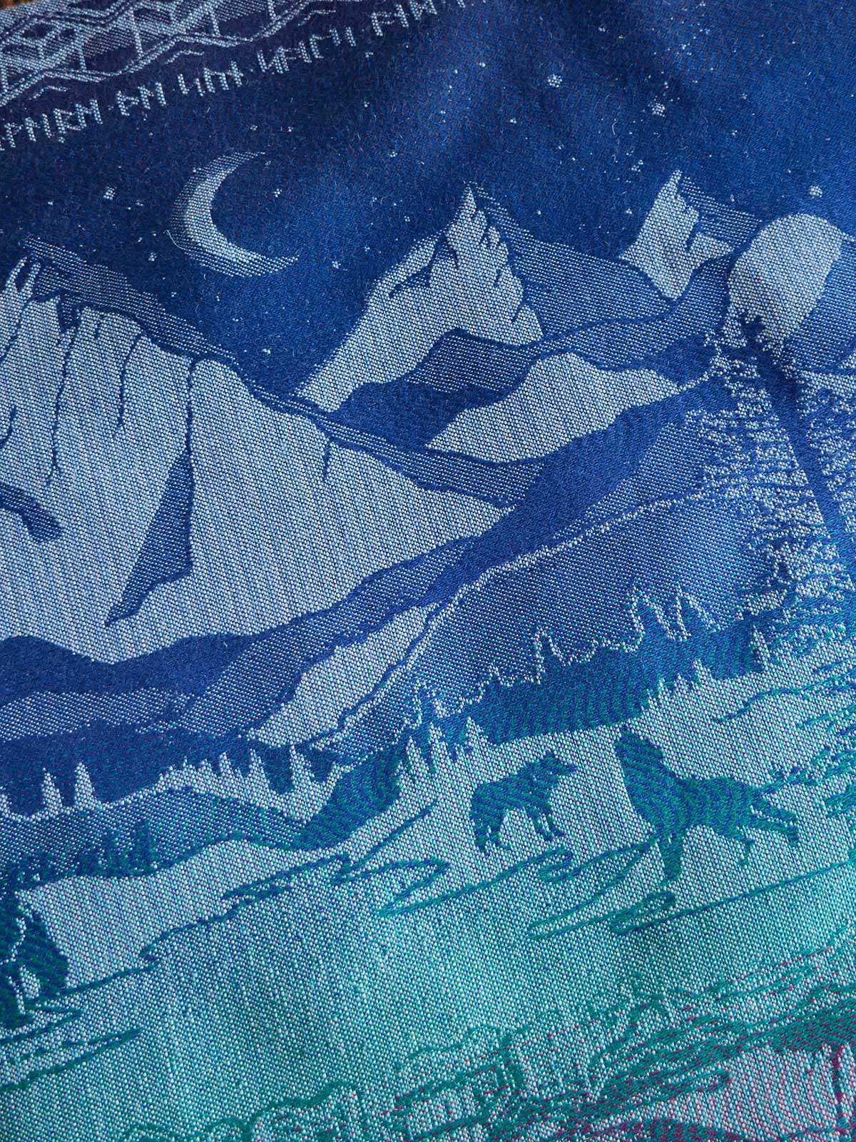 Textile with wolf and mountain pattern in blue tones