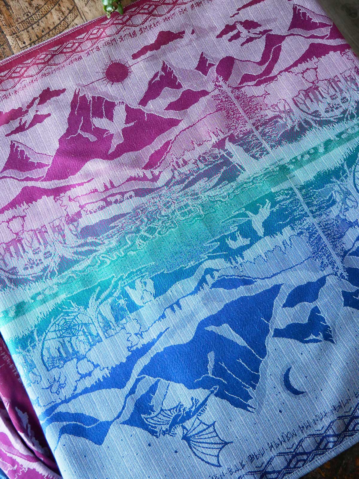 Reverse side of colourful fabric with printed patterns of people and animals on a gradient background