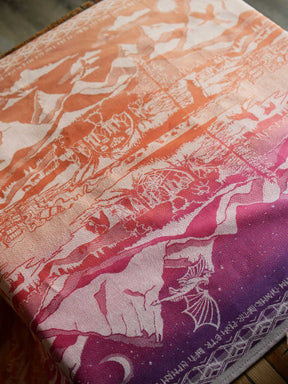 Close up of The Lord of the Rings Hobbit Quest fabric with orange at the top fading to deep purple at the bottom. 