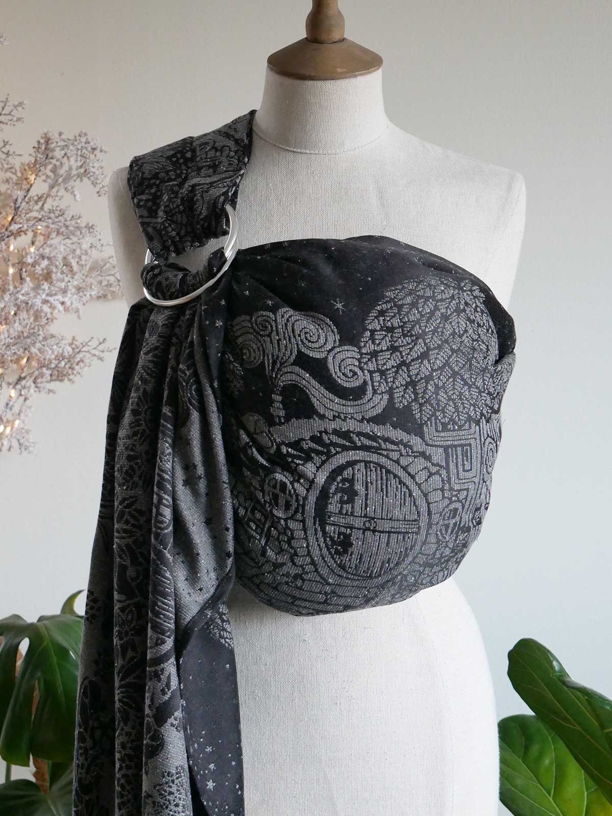 Black ring sling on a mannequin with silvery hobbit house design