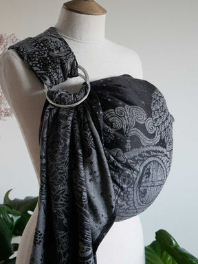 Side profile of black ring sling on a mannequin with silvery hobbit house design