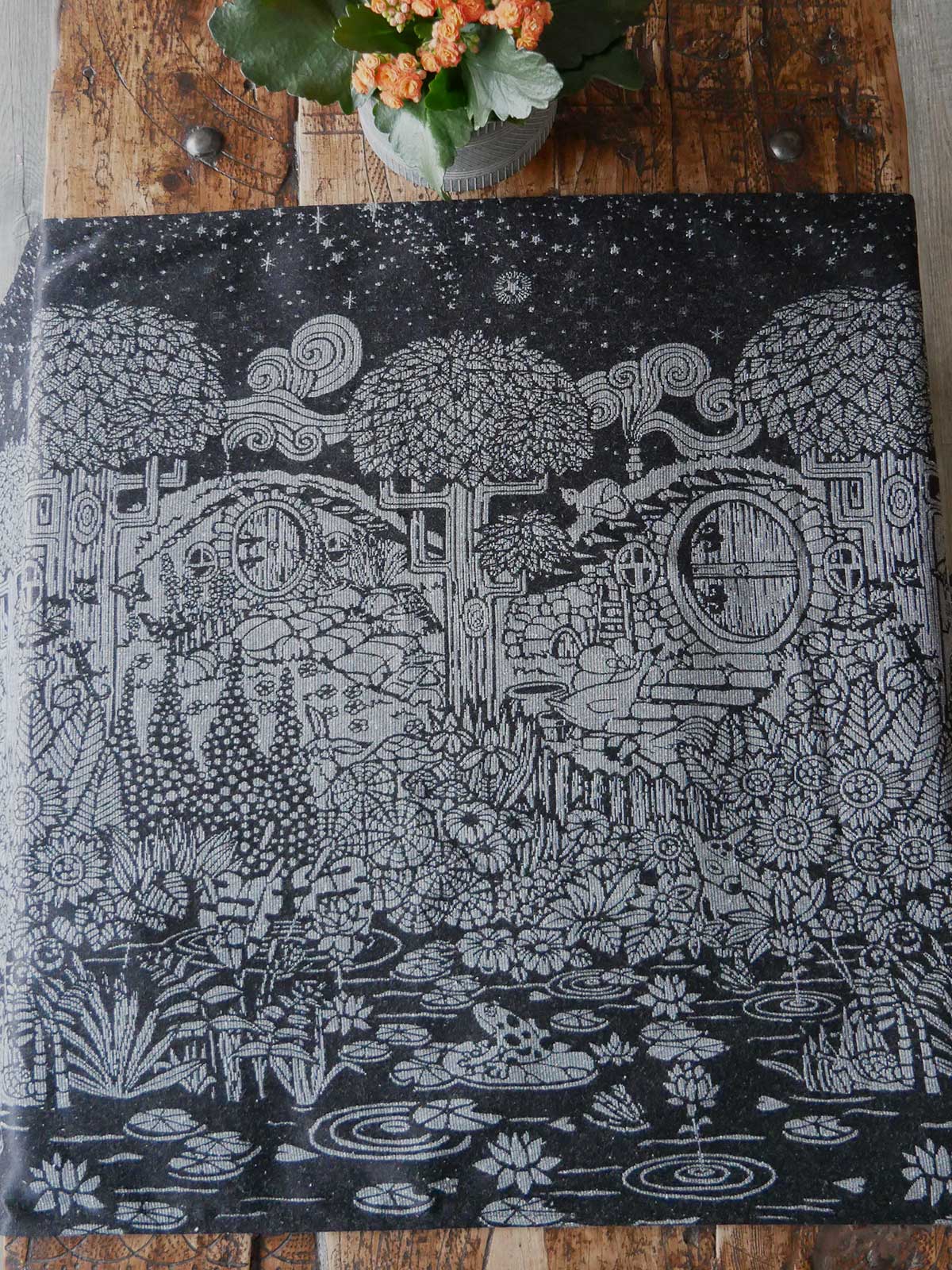 Black fabric with silvery hobbit house and foliage design.