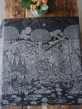 Black fabric with silvery hobbit house and foliage design.