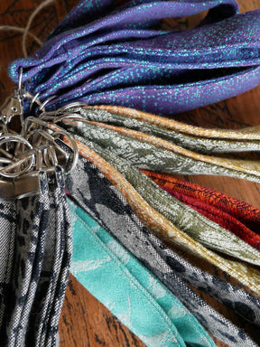 Collection of colorful fabric keychains on a wooden surface