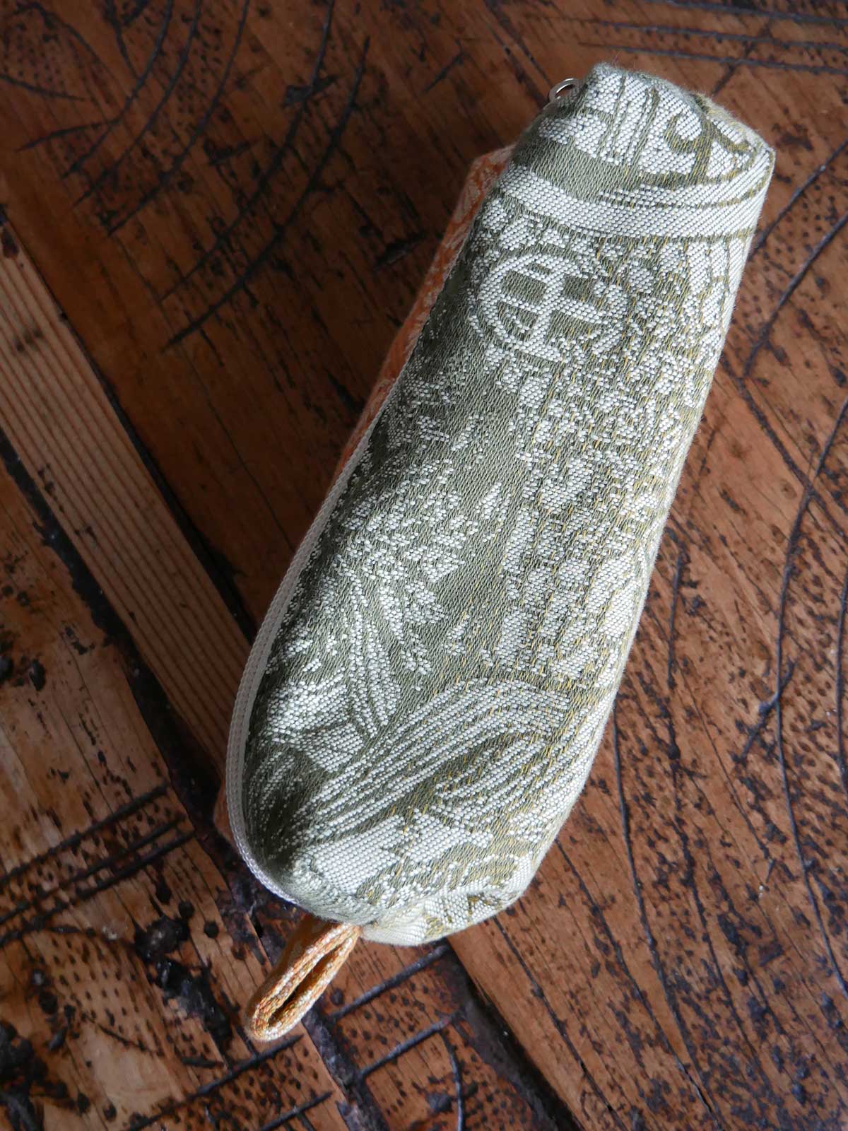 Green textured pouch on a wooden surface