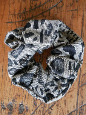 Leopard print scrunchie on a wooden table. 