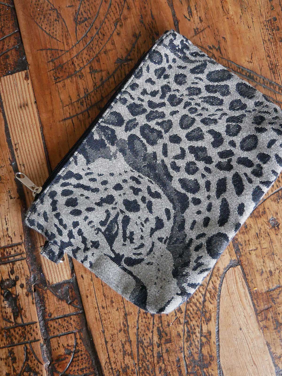 Animal print zip pouch on wooden table.