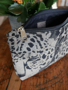 Animal print zip pouch with plant in background.