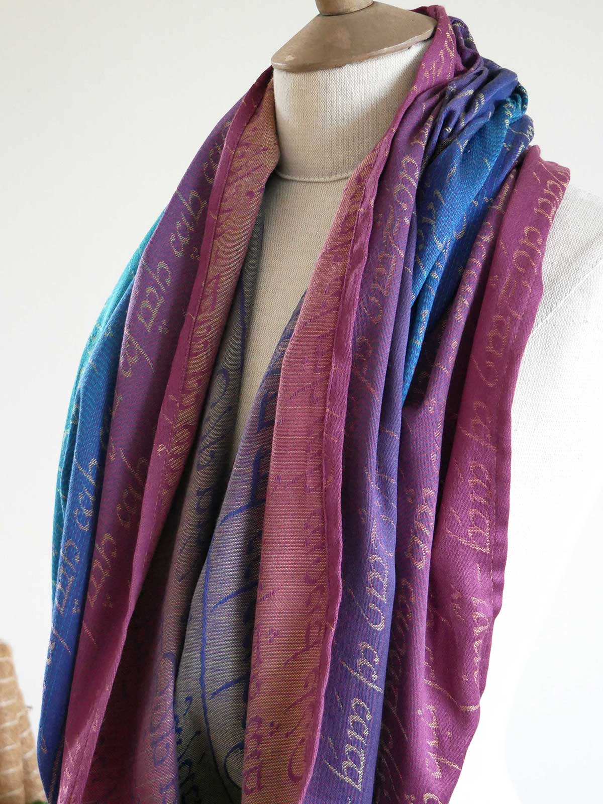 Mannequin wearing a colorful scarf with text on a white background
