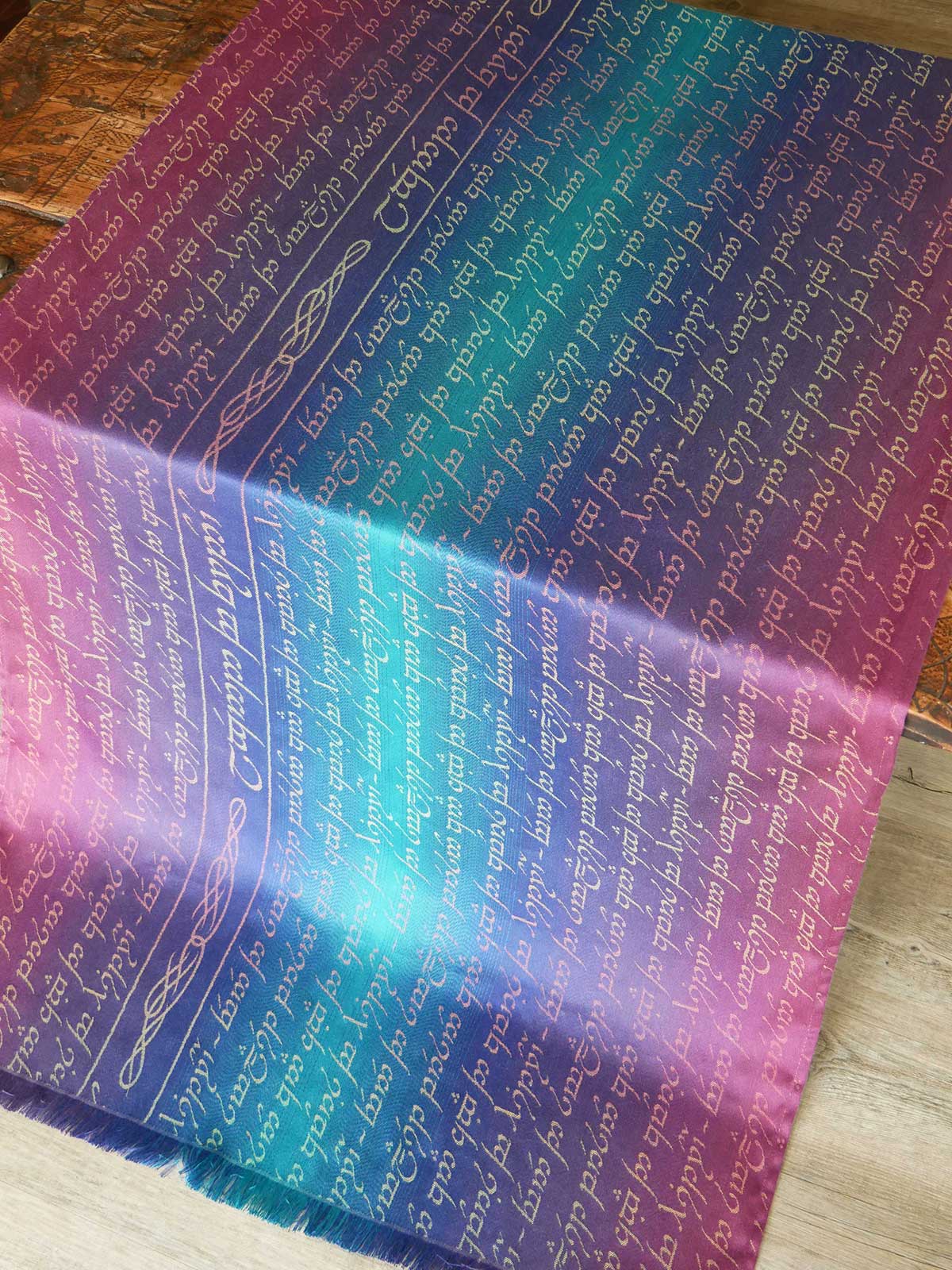 Gradient fabric with printed text on a wooden surface