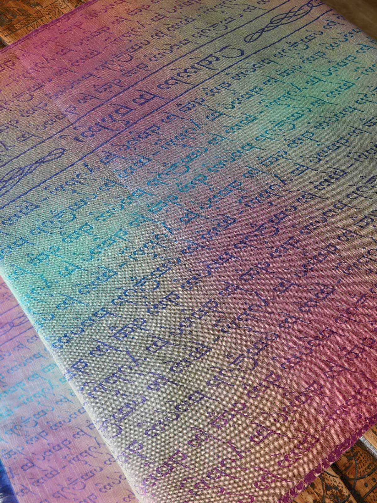 Reverse of gradient fabric with printed text on a wooden surface