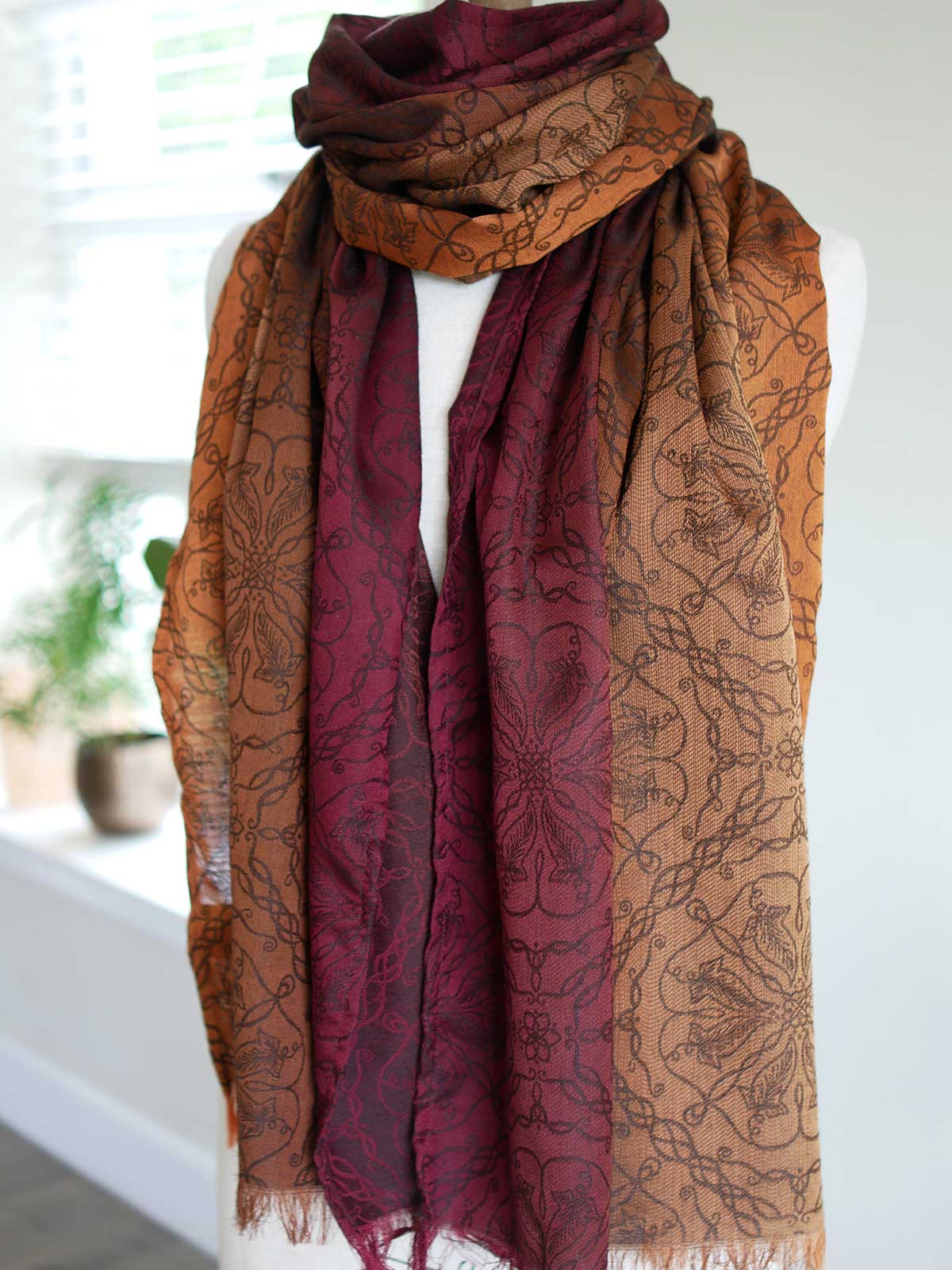 Red and carmel coloured scarf on a mannequin.