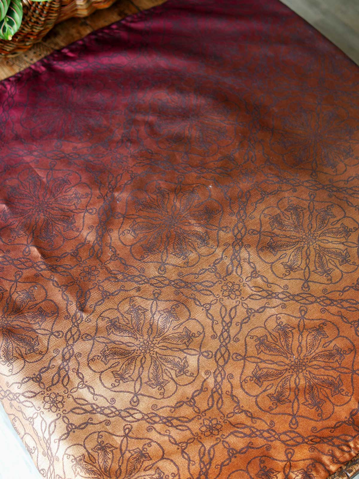 Red and carmel coloured fabric on a wooden table.