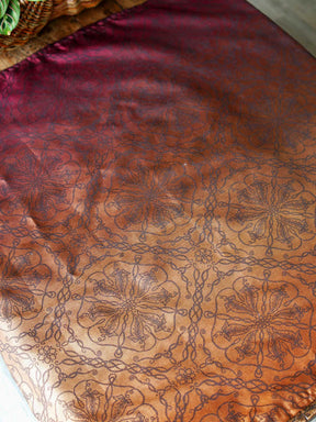 Red and carmel coloured fabric on a wooden table.