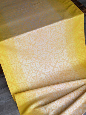 Lemon yellow graduated fabric woven with Ice Cotton draped on a table. 