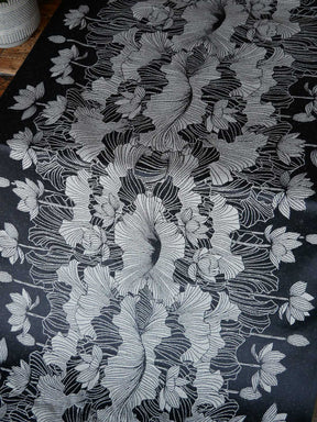 Floral embroidery pattern on a dark fabric background