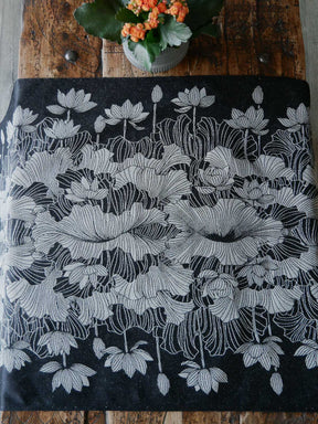 Floral patterned fabric on a wooden surface with a small plant.