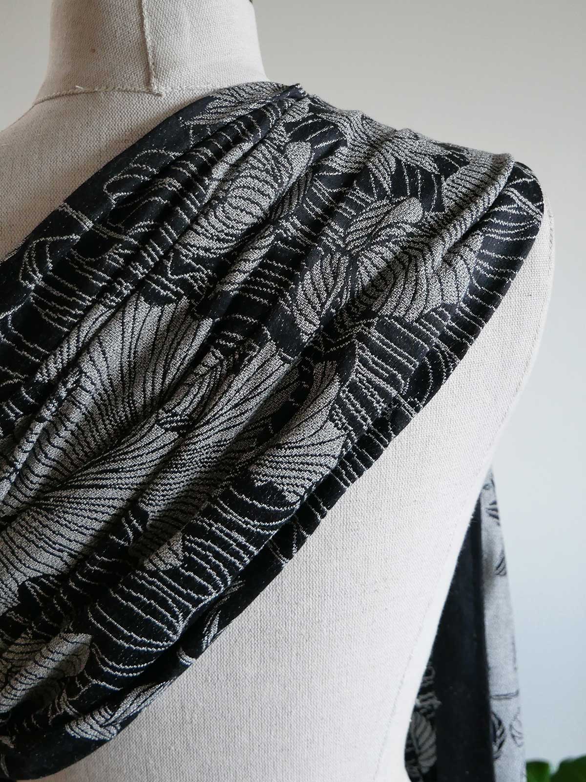 Black and white patterned sling draped over a mannequin on a plain background