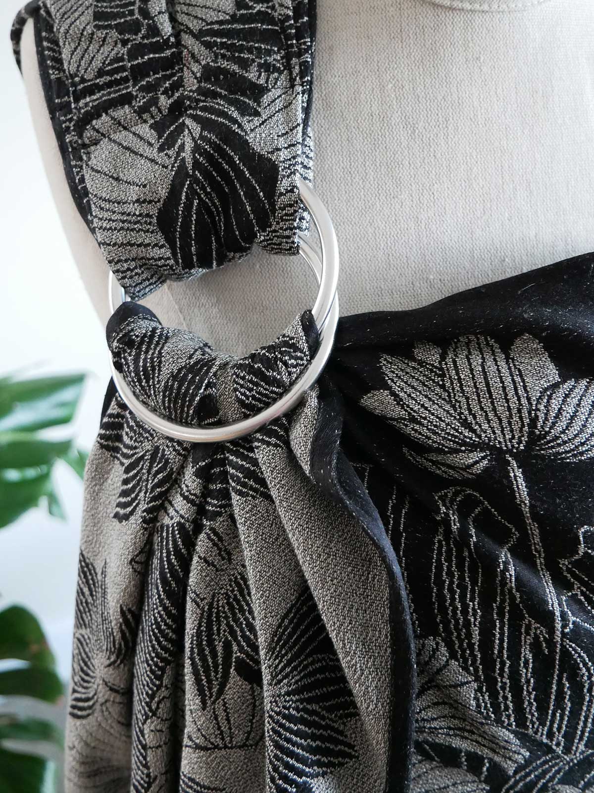 Black and gray patterned ring sling on a mannequin with a blurred background