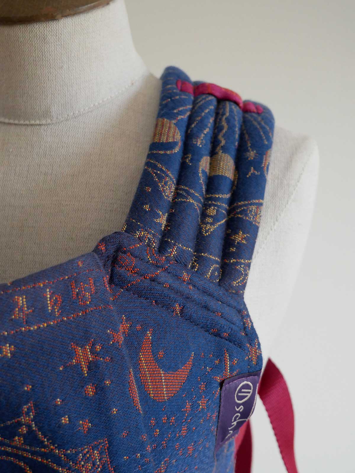 Blue fabric baby carrier strap with star and moon pattern on a mannequin