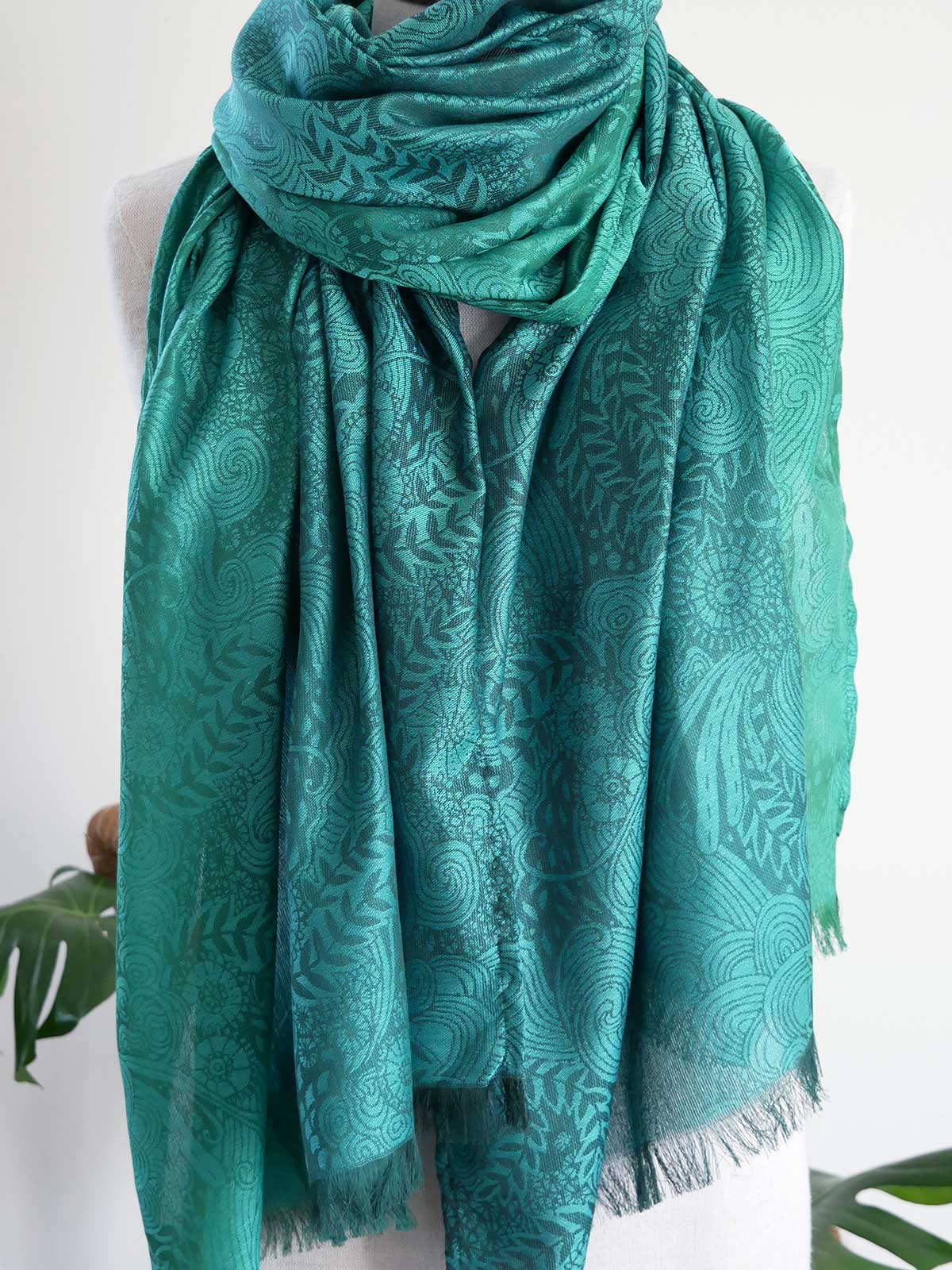 Teal patterned scarf on a white background