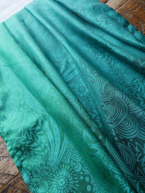 Teal fabric with intricate patterns on a wooden surface