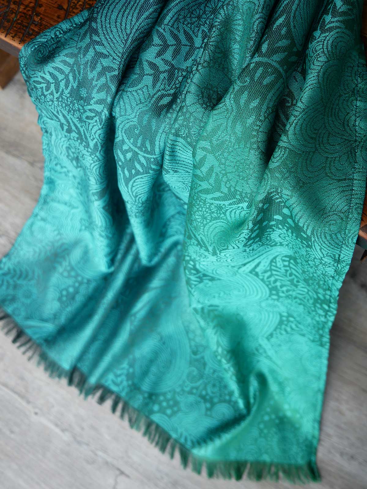 Green patterned fabric draped over a wooden surface