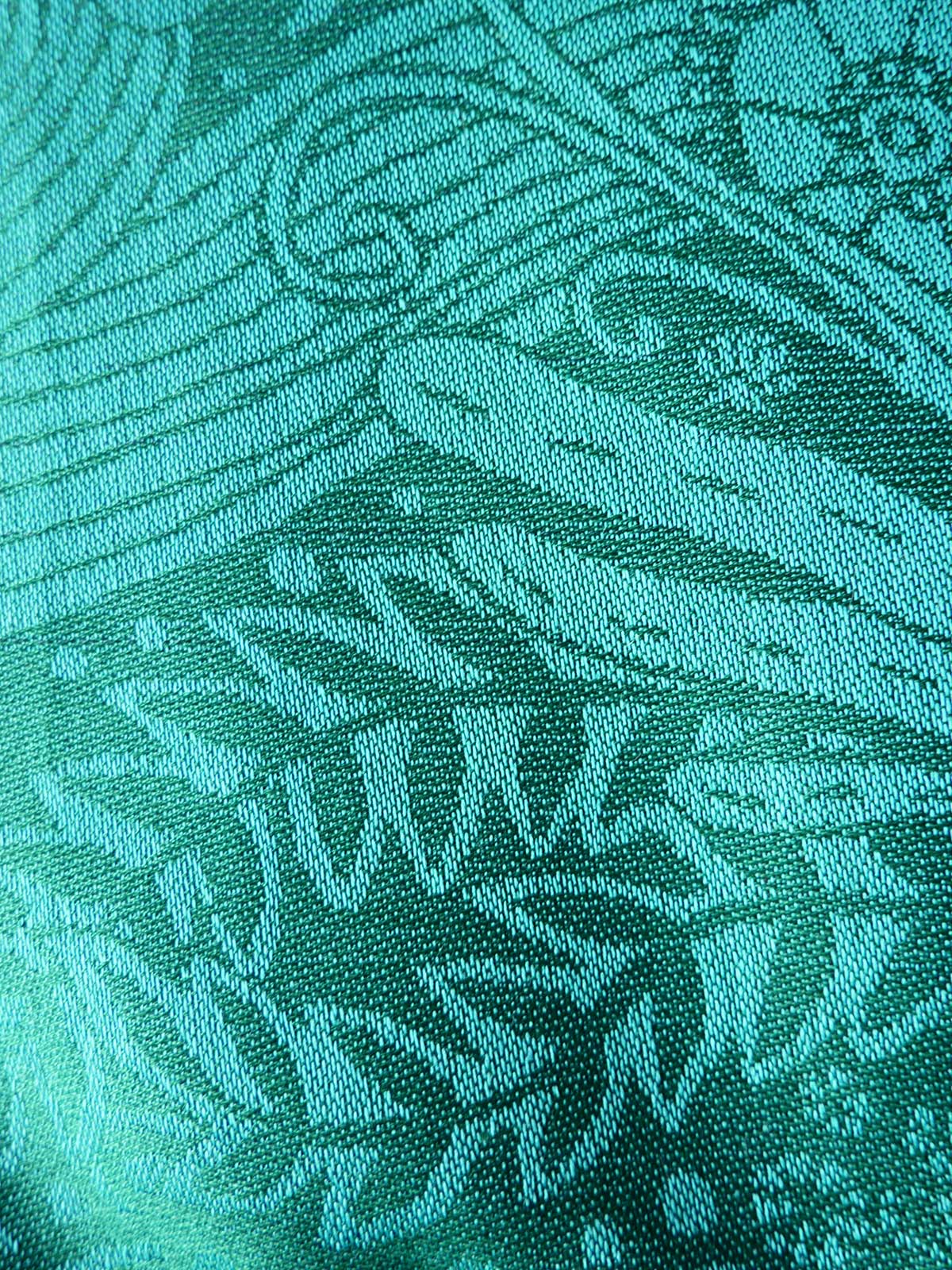 Close-up of teal fabric with intricate pattern