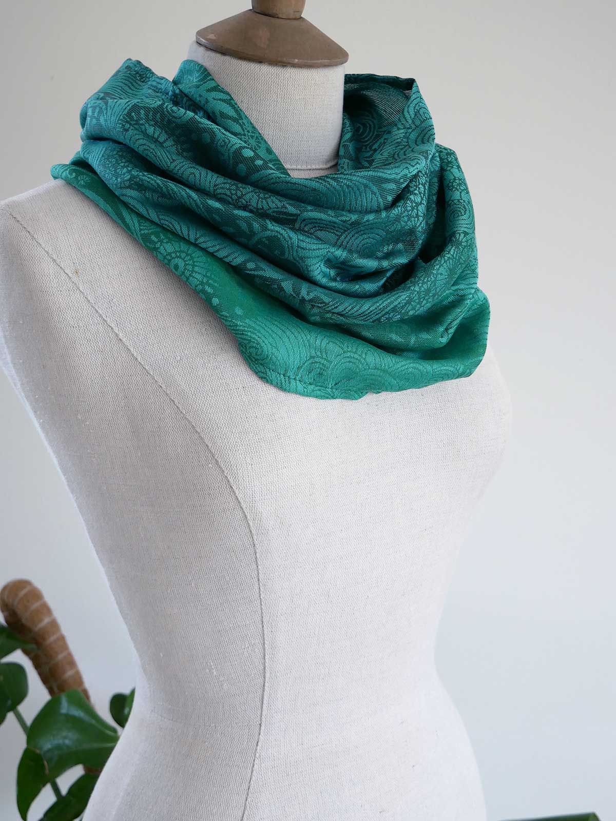 Green textured neckwear on a mannequin against a white background