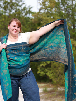 Woman with a blue teal woven wrap with a mountain pattern