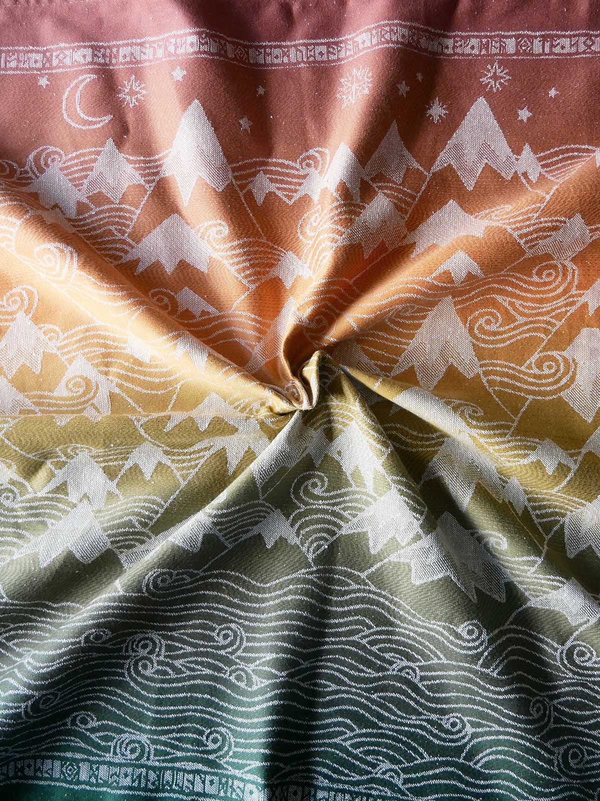 Close-up of fabric with mountain and  pattern in brown, orange, and green.