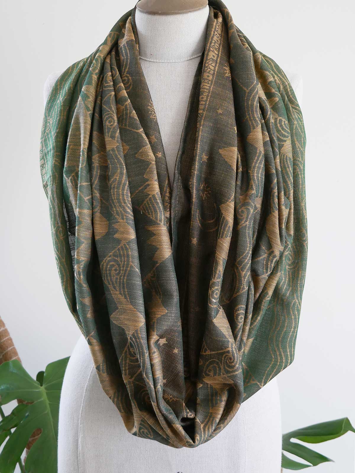 Green patterned loop scarf on a mannequin with a white background