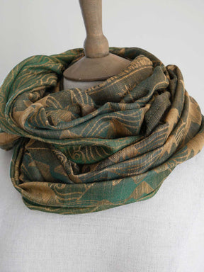 Green and gold loop on a mannequin head against a white background