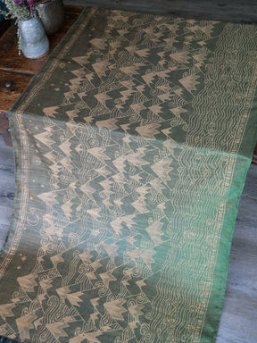 Green and gold patterned fabric on a wooden surface