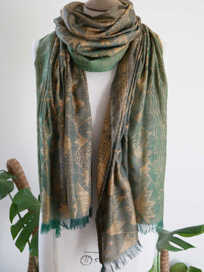 Green patterned scarf on a mannequin with a white background