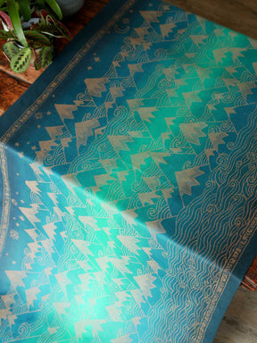 A blue teal woven wrap with a gold mountain pattern