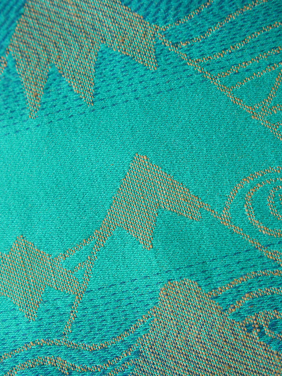Close up of a blue teal fabric with a gold mountain pattern