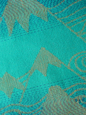 Close up of a blue teal fabric with a gold mountain pattern