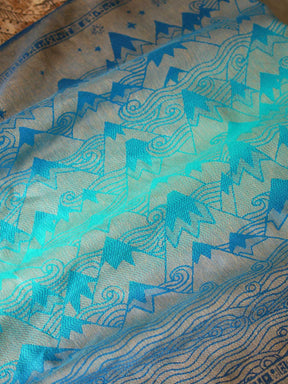 Reverse of a blue teal fabric with a gold mountain pattern