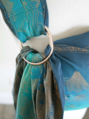 Close up of blue teal ring sling with a gold mountain pattern on a mannequin