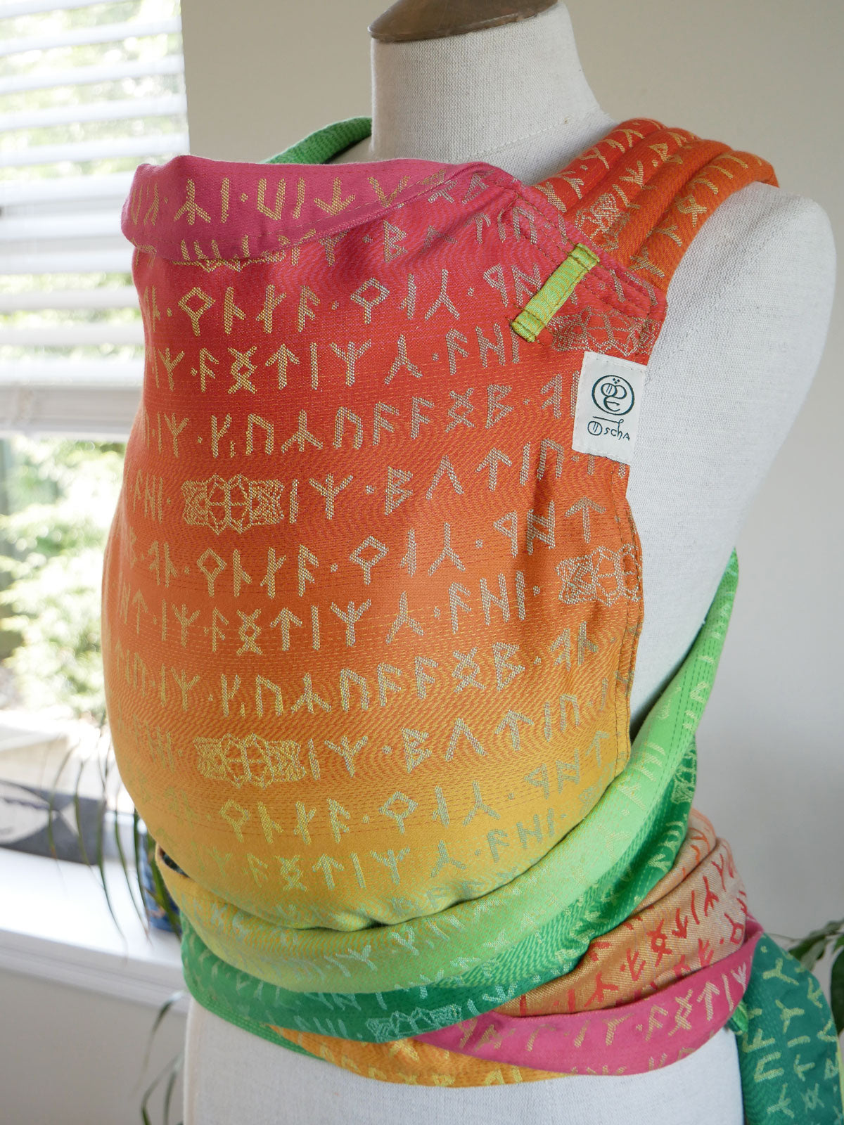 Colourful Moria Citrus Cairis baby carrier with text pattern on a mannequin