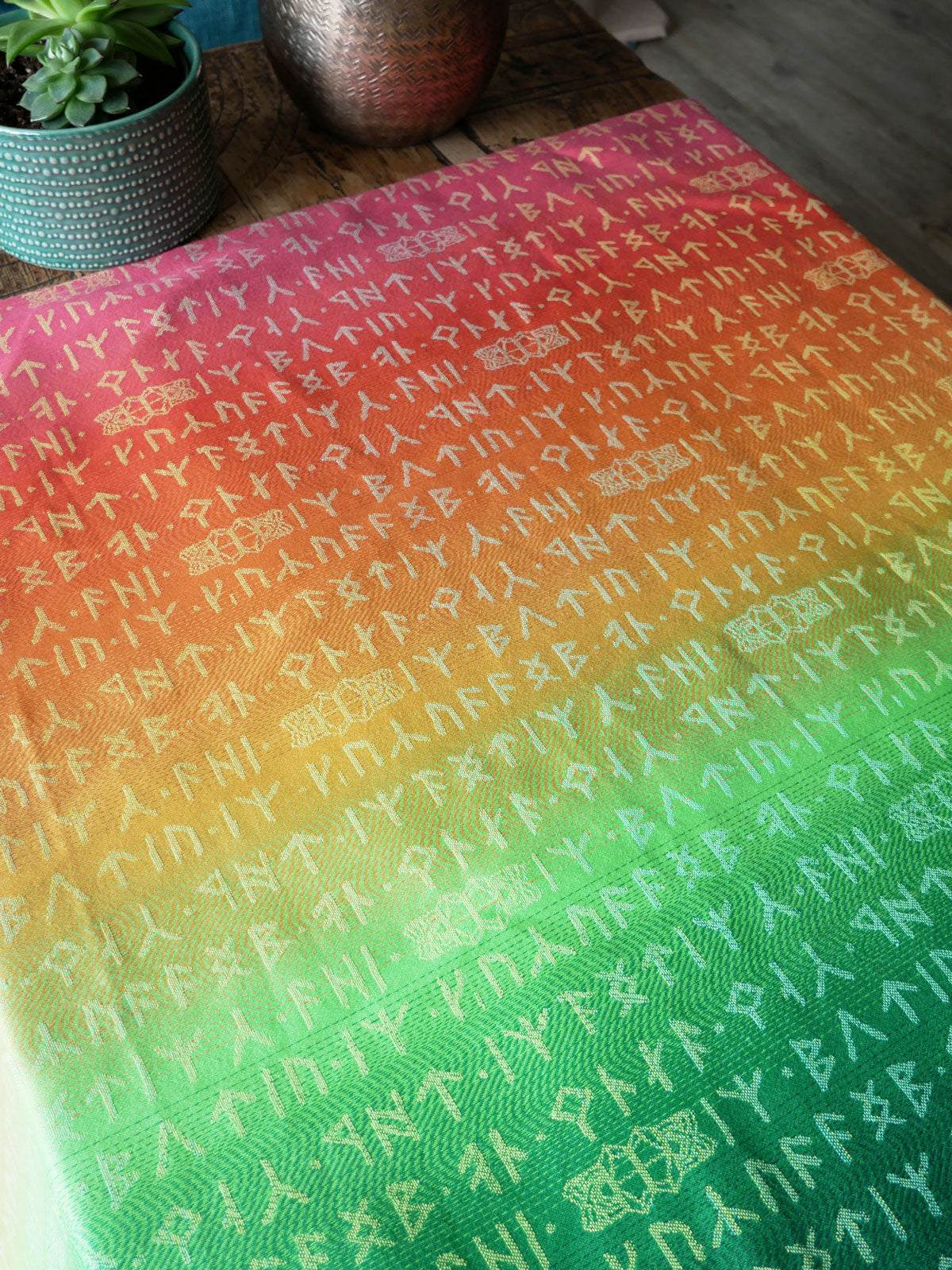 Gradient fabric with text pattern of runes on a wooden surface