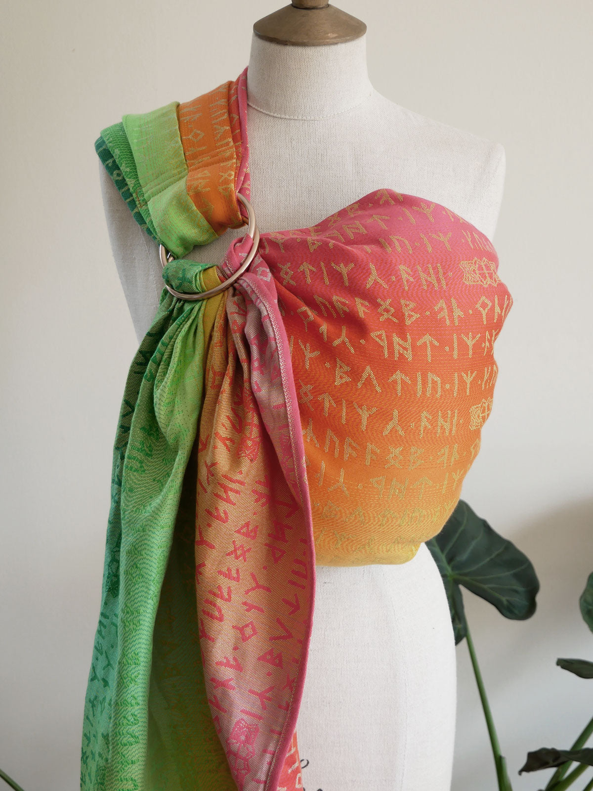 Colourful Moria Citrus Ring Sling with green, orange, and pink runes on a mannequin against a white background.